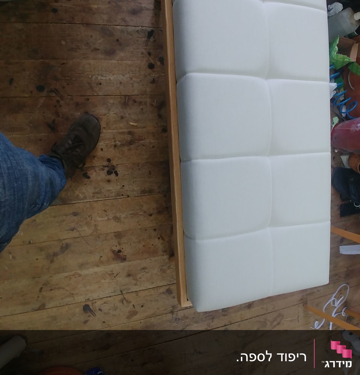 ספה מרופדת בלבן על רצפת עץ